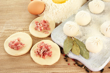 Obraz na płótnie Canvas Raw dumplings, ingredients and dough, on wooden table