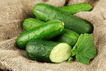 Tasty green cucumbers on sackcloth background