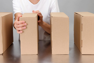 Worker working with boxes at conveyor belt, on grey background