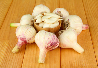 Fresh garlic on wooden table, on bright background