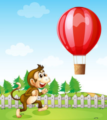 A monkey running outside the fence with a hot air balloon