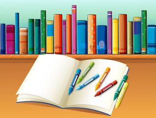 An empty notebook with crayons in front of the shelf with books