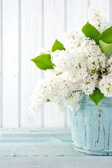 White lilac spring flowers in a blue vase