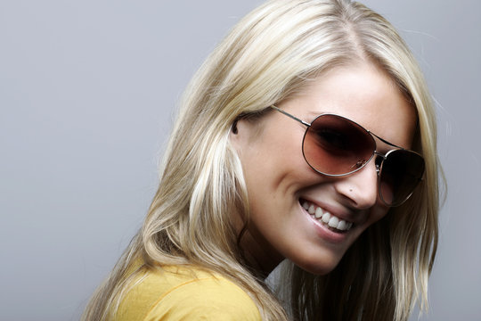 Attractive and cheerful female model in sunglasses