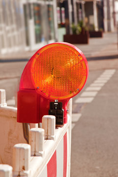 orange road construction lamp and barrier