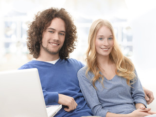 Serene young smiling couple with laptop
