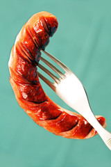 Grilled sausage on a fork.