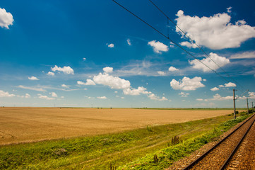Fototapeta na wymiar Scenic railroad in rural area and blue sky with white clouds