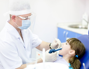 dentist using dental filling gun on kid