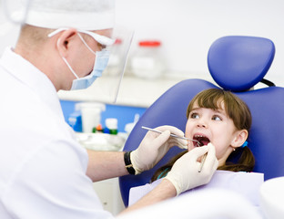 dental examining being given to little girl by dentist