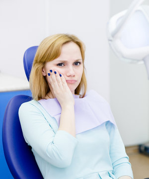 Woman At The Dentist Complains Of Toothache. Looking At Camera.