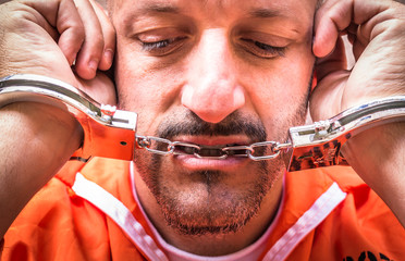 Sad Man with Handcuffs in Prison
