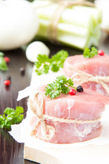 Fresh fillet of raw meat with spices and herbs on a wooden backg