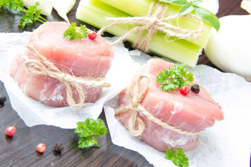 Fresh fillet of raw pork tied with twine on wrapper with spices