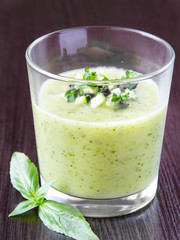 Vegetable cream soup with avocado, herbs, zucchini and black oli