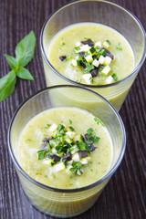 Vegetable cream soup with avocado, herbs, zucchini and black oli
