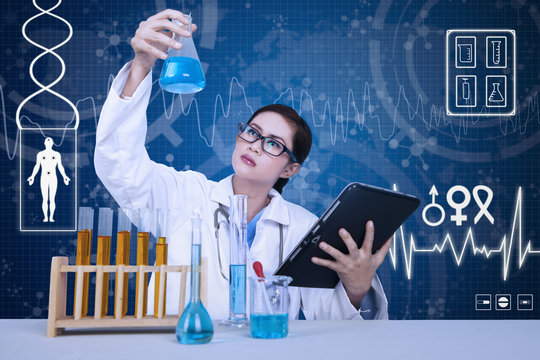 Beautiful scientist analysing solution on blue background