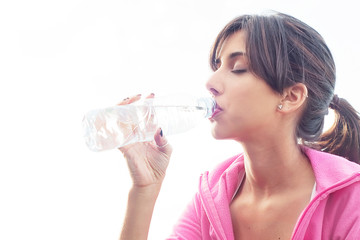 Young caucasian woman drinking water from a bottle
