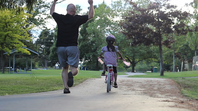 Proud Father Encourages Daughter Riding Her Bike