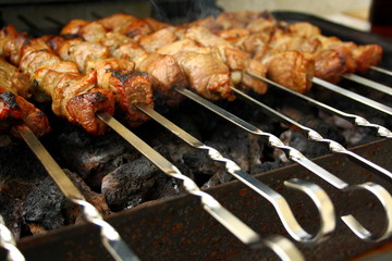 Marinated lamb grilling on metal skewer