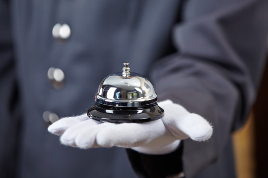 Hand mit Hotelglocke