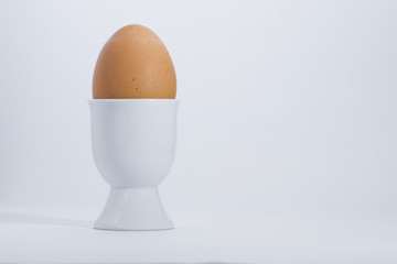 Boiled egg in white egg cup