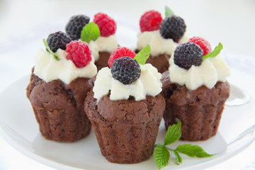 Chocolate muffins with raspberries and cream.