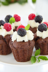 Chocolate muffins with raspberries and cream.