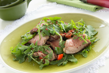 Salad with roast beef, arugula and tomatoes.