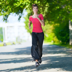 Runner - woman running outdoors in green park