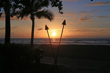 Beautiful sunset in Hawaii with tiki torches