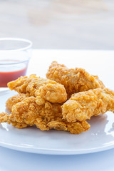 Chicken Strips on White Plate with Hot Sauce
