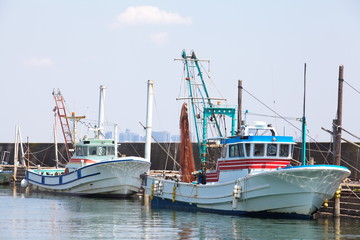 Fototapeta na wymiar Fishing boat tied up against the pier