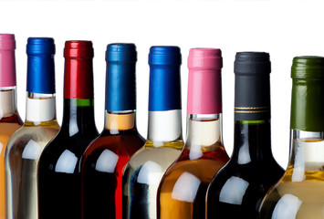 Some wine bottles in a row against white background