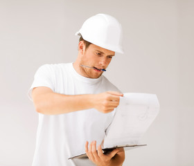 male architect looking at blueprint