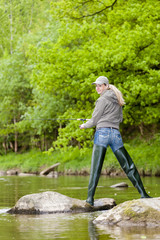Obraz premium woman fishing in Sazava river, Czech Republic