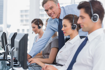 Smiling manager helping call centre employee