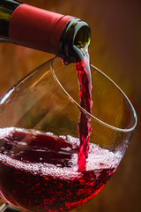 Wine pours into the glass of the bottle