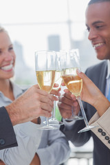 Business team celebrating with champagne and clinking glasses