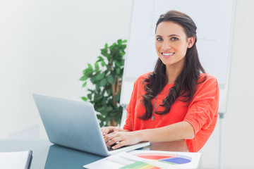 Cheerful designer working on her laptop