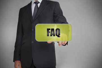 Businessman selecting green tag with the word faq written on it