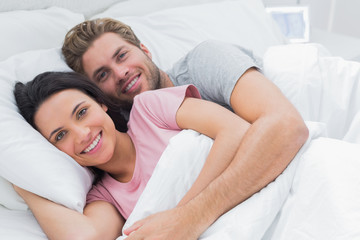 Fototapeta na wymiar Couple embracing in bed