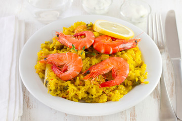 rice with shrimps and lemon on white plate