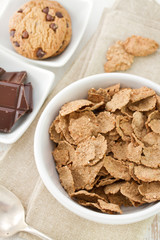 cereals in white bowl and cookies with chocolate