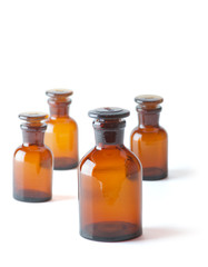 Small chemical glass bottles on white background