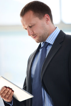 Portrait of businessman working on electronic tablet