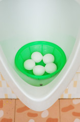 White naphthalene balls in white porcelain urinal