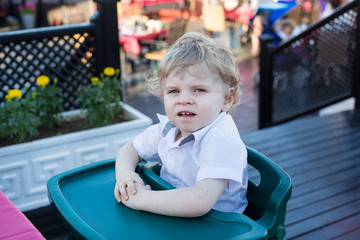 Portrait of beautiful little toddler boy sitting in outdoor rest