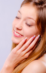 Fototapeta premium Beautiful girl with closed eyes touches her face