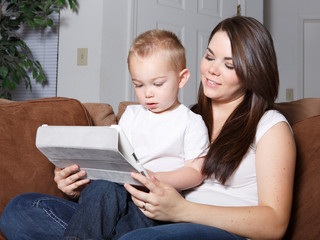 Smiling woman and her son reading on tablet together